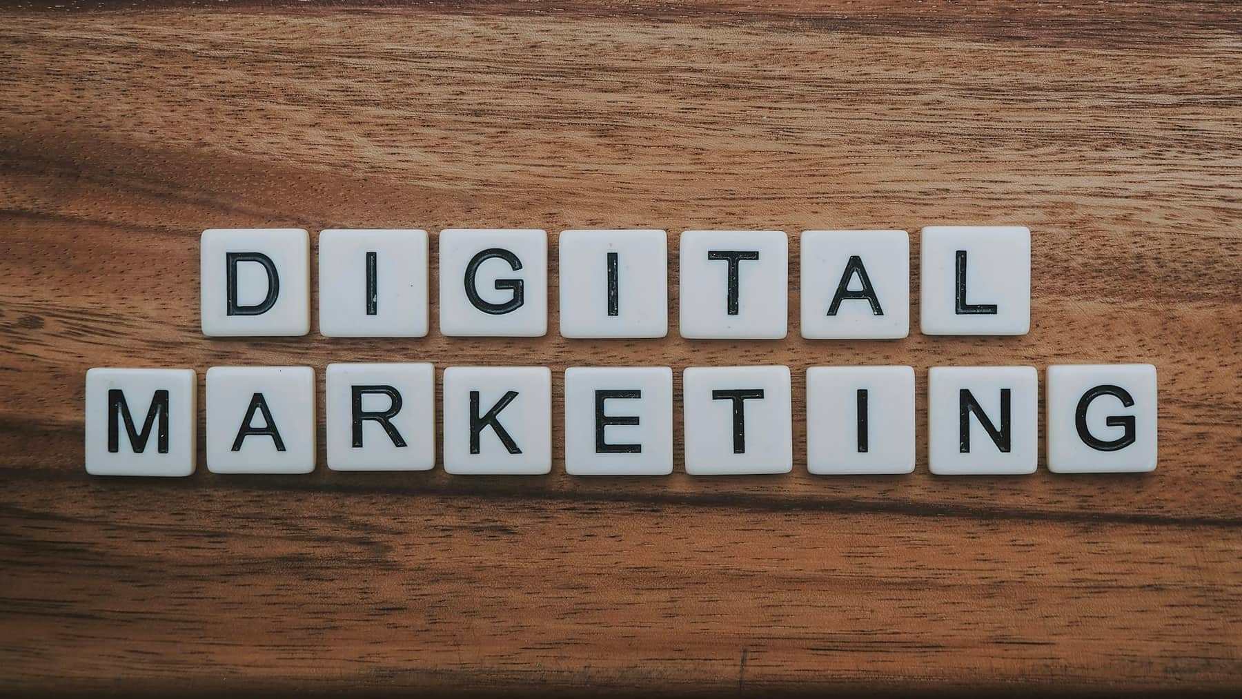 Letter tiles spelling digital marketing on a wooden table